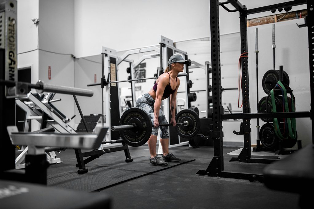 Recomposición corporal: ¿se puede perder grasa y ganar músculo a la vez? 1 Mujer entrenando fuerza con peso libre como parte de un proceso de recomposición corporal